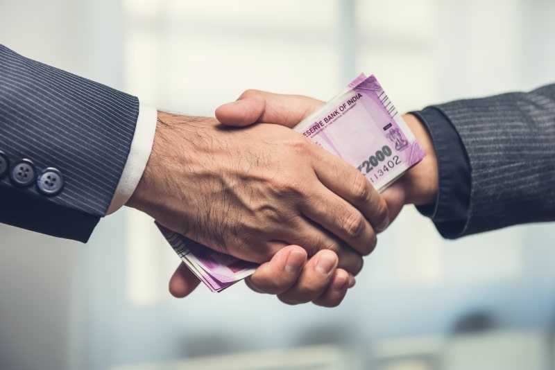 businessmen-making-handshake-with-money-indian-rupee-currency-hands (6)-min